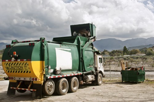 Crew wearing hi-vis PPE loading a skip safely